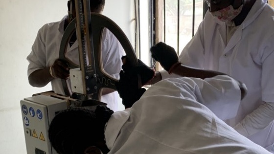 Three people dismantling equipment to recycle it